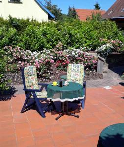 2 sillas y una mesa en un patio con flores en Fewo Kasch, en Binz