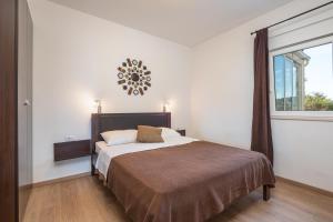 - une chambre avec un lit et une grande fenêtre dans l'établissement Apartments Didan, à Cavtat