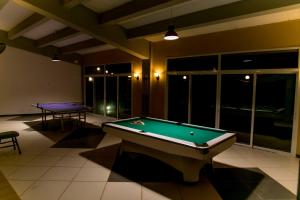 a room with a pool table and two tables at Tropic Garden Hotel in Banjul