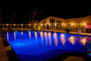 a swimming pool at night with blue illumination at Tropic Garden Hotel in Banjul