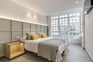 a bedroom with two beds and a large window at A Casa do Latoneiro in Caldas de Reis