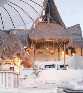 an outdoor dining area with tables, chairs and umbrellas at Gravity Boutique Hotel in Uluwatu