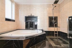Un baño grande con bañera y ducha. en Folkowy Dom dla 14 osób z sauną i grillowiskiem - Dream Apart, en Szczyrk 38 fotos más