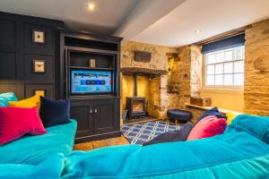 sala de estar con sofá azul y TV en Number 6 Stamford - Boutique Grade II Listed Townhouse en Stamford