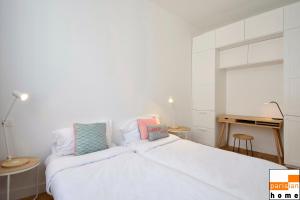 een slaapkamer met een wit bed met 2 kussens erop bij 202117 - Appartement 6 personnes à Paris in Parijs
