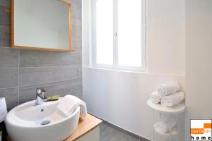 een badkamer met een witte wastafel en een raam bij 202117 - Appartement 6 personnes à Paris in Parijs