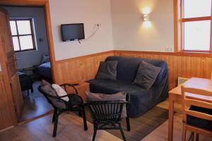 a living room with a couch and a tv at Egilsstaðir 1 Guesthouse in Villingaholt