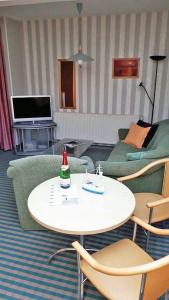 een woonkamer met een tafel, stoelen en een bank bij Fewo Kasch in Binz