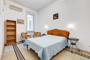 ローマにあるAppartamento con 3 camere da letto e 2 bagni vicino al Vaticanoの白いベッドルーム(ベッド1台、椅子2脚付)