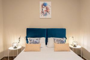 a bed with a blue headboard and pillows at Bright & Stunning Flat in the City Centre in Zakynthos Town