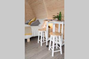 Habitación con cama, mesa y taburetes en Isla Pod, Kilry eco pods, en Blairgowrie