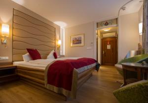 een hotelkamer met een bed en een stoel bij Hotel König in Passau