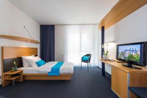 a hotel room with a bed and a television at SEEhotel Friedrichshafen in Friedrichshafen