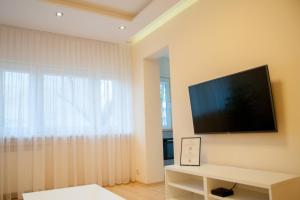 sala de estar con TV de pantalla plana en la pared en Apartament Turoszowska en Lodz
