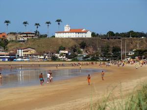 a group of people walking on a beach at Pousada Nativo's in Nova Almeida