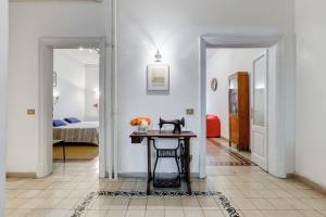 un corridoio con tavolo e una camera con letto di Appartamento con 3 camere da letto e 2 bagni vicino al Vaticano a Roma