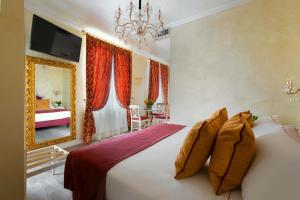 a hotel room with a bed, table, lamps and curtains at Relais Empire in Verona