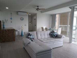 uma sala de estar com um sofá branco e uma mesa em SANTA MARTA OASIS en ZAZUE em Santa Marta