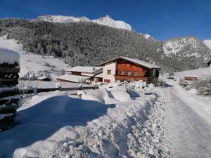 una casa cubierta de nieve junto a una carretera en Abenteuerhof en Nauders