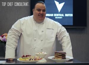 un chef está sosteniendo una bandeja de comida en Urban Central Suites - Beirut en Beirut