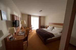 a hotel room with a bed and a desk at Hotel & Café Strandeck in Prerow