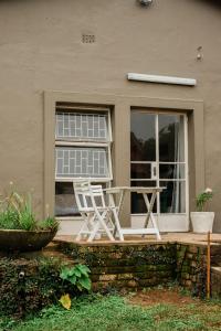 un paio di sedie seduti sul portico di una casa di Rondebossie Farm Retreat a Magoebaskloof