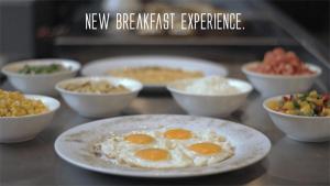 a plate of eggs on a counter with bowls of food at Urban Central Suites - Beirut in Beirut