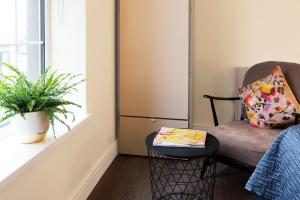 un soggiorno con sedia e tavolo di Blue Door Apartments a Newcastle