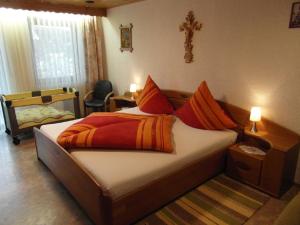 ein Schlafzimmer mit einem Bett mit einem Kreuz an der Wand in der Unterkunft Schönberger-Hof in Wernberg-Köblitz