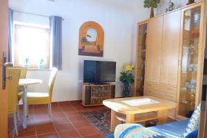 a living room with a tv and a table at Haus Schloßwiese in Bad Füssing