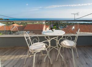 a table and chairs on a balcony with a view of the ocean at Villa Sv. Vid in Sevid
