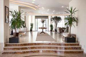 a lobby with stairs and potted plants and a table at Hotel Nettuno in Cervia