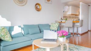 a blue couch in a living room with a laptop on a table at Radazul Marina Seafront 12 in Radazul