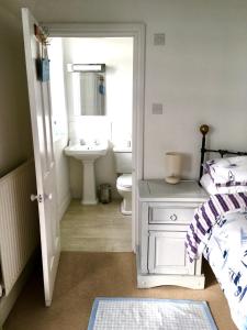 La salle de bains blanche est pourvue d'un lavabo et de toilettes. dans l'établissement Lyme Regis renovated period seaside flat, à Lyme Regis