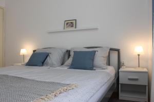 een slaapkamer met een bed met blauwe en witte kussens bij Hope Apartments in Vodice