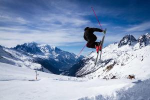 Eine Person, die im Schnee einen Trick auf Skiern macht in der Unterkunft Penthouse le Bartavel - Chamonix All Year in Chamonix-Mont-Blanc