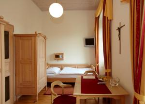 Habitación pequeña con cama, mesa y sidra de mesa en Seminarzentrum Stift Schlägl, en SchlÃ¤gl