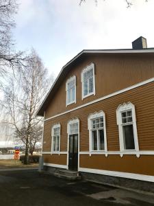 a brown building with white windows and a door at Willa Strand in Kristiinankaupunki