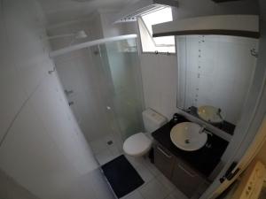 uma casa de banho com um chuveiro, um lavatório e um WC. em Edificio Long Beach em Balneário Camboriú