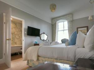 a bedroom with a large white bed and a window at Coul House Hotel in Contin