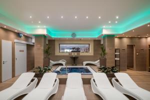 a conference room with a hot tub and white chairs at Bükkös Hotel & Spa in Szentendre