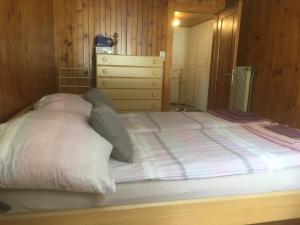 a bedroom with a large white bed with a dresser at Alpen-Sonne in Sankt Niklaus