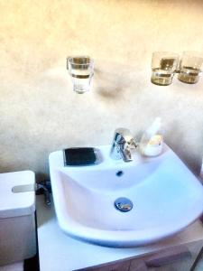 a white sink with two glasses on top of it at Alpen-Sonne in Sankt Niklaus