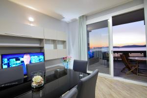 a dining room with a table with chairs and a television at Luxury Garibaldi in Alghero