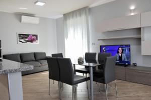 un soggiorno con tavolo, sedie e TV di Luxury Garibaldi ad Alghero