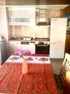 a kitchen with a table with a red table cloth at Alpen-Sonne in Sankt Niklaus