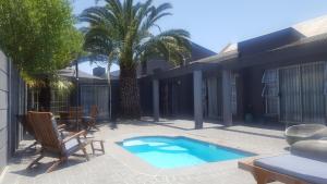 a house with a swimming pool and a palm tree at Hayley's Place in Cape Town