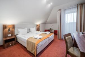 a bedroom with a large white bed and a desk at Bükkös Hotel & Spa in Szentendre +37 photos