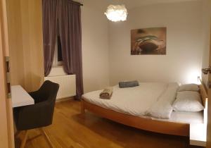 ein Schlafzimmer mit einem Bett, einem Stuhl und einem Fenster in der Unterkunft Apartman Zoe in Zagreb