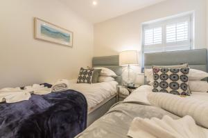 a bedroom with two beds and a lamp in it at 5 Four Seasons in Carbis Bay